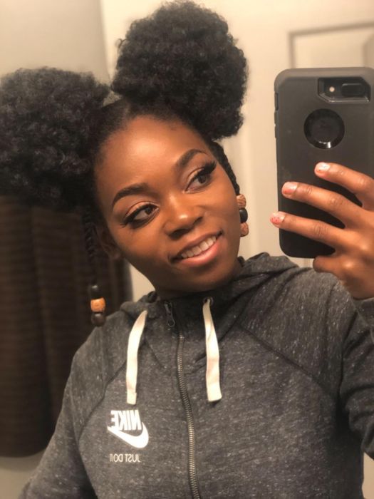 A reviewer wearing the foundation in the shade Mocha, taking a mirror selfie.