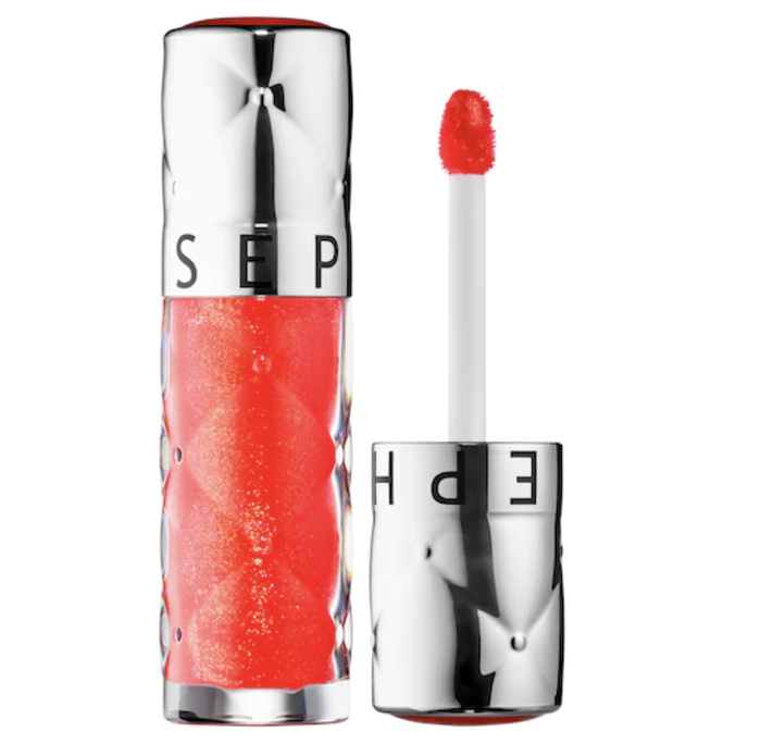 A tube of lip product next to its applicator.
