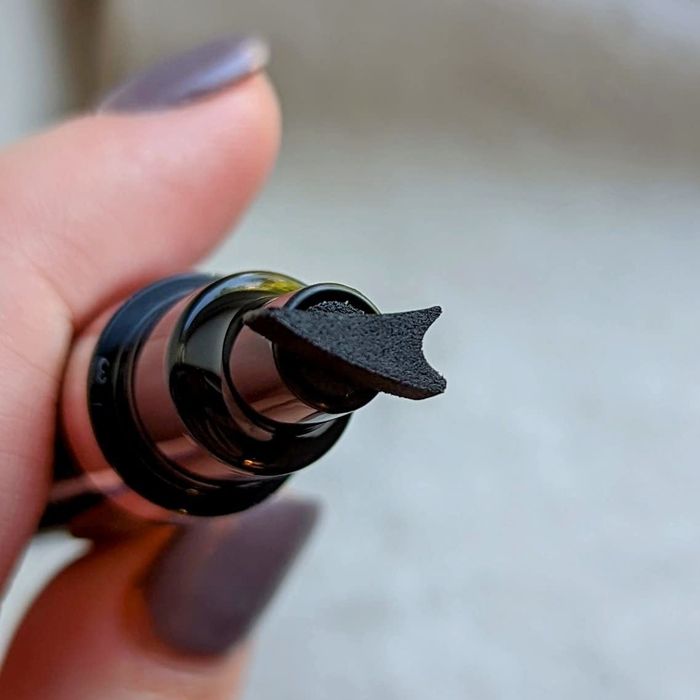 A reviewer’s eyeliner pen featuring a wing-shaped stamp.