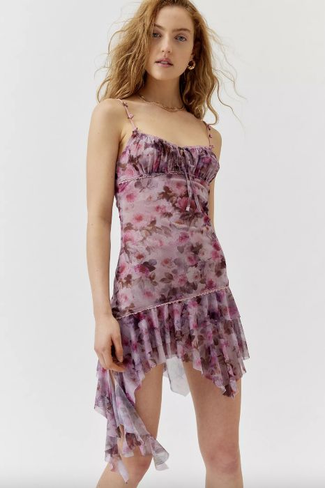 model posing in a floral dress featuring an asymmetrical hemline