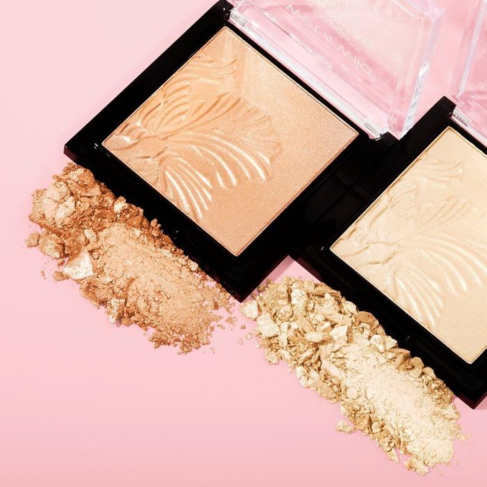 two compacts of the highlighter in different shades, with some crushed product displayed in front