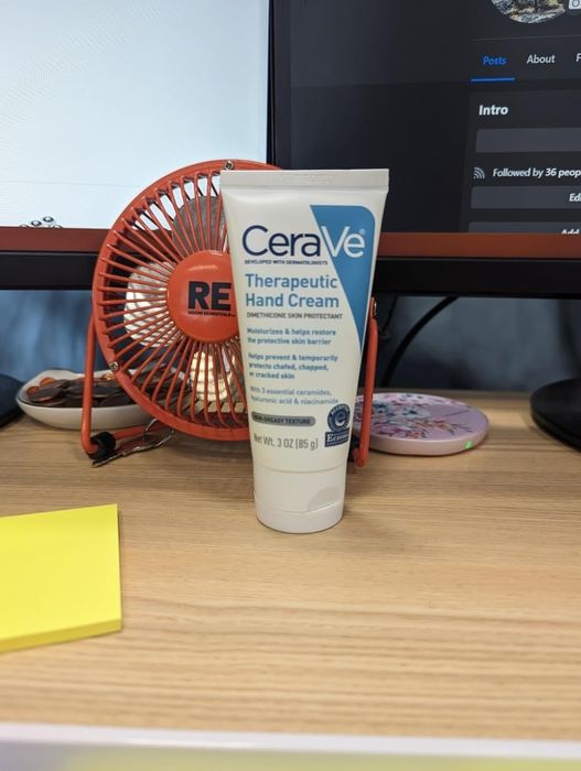 Photo of the reviewer showcasing a tube of CeraVe Therapeutic Hand Cream.