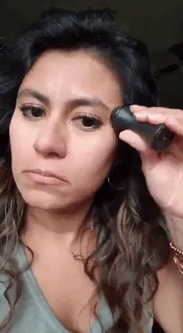 A user demonstrating the effectiveness of the Revlon oil-absorbing volcanic face roller
