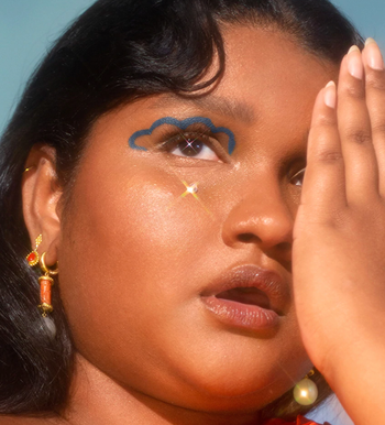 a model displaying a creative blue cloud-like design on their eyelid using the blue eyeliner