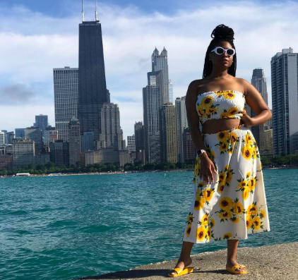 A reviewer wearing the white sunflower-print set, featuring a cropped tube top and a matching midi skirt