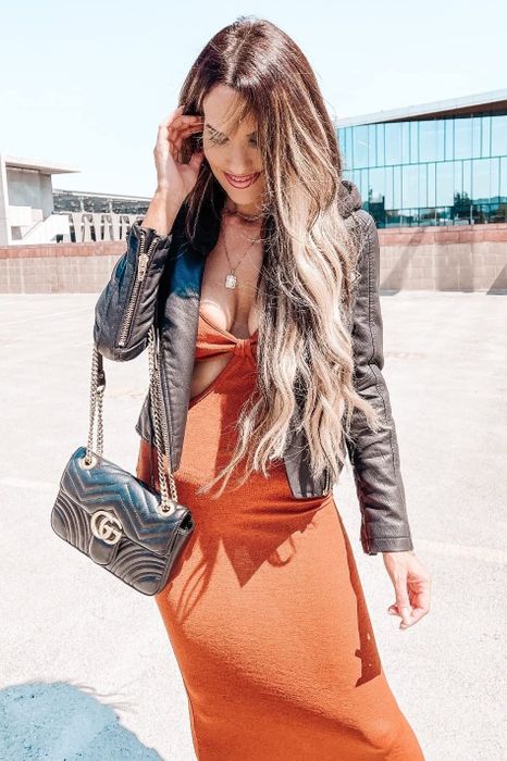 a reviewer wearing the orange dress paired with a leather jacket