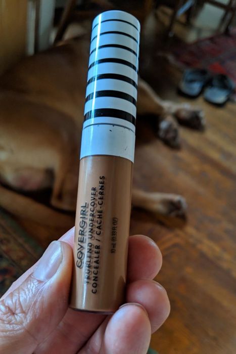 A reviewer holding the concealer for display