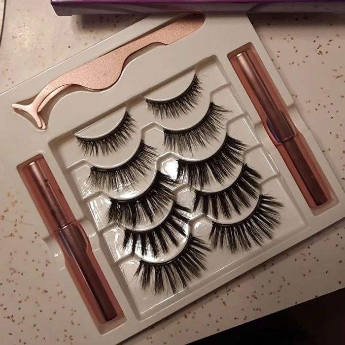 A reviewer showing a photo of the magnetic false lashes, application tool, and eyeliner