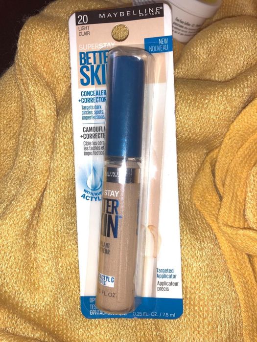 A reviewer displaying the concealer in its original packaging