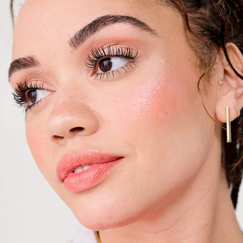 A close-up of a model's face showcasing glowing makeup
