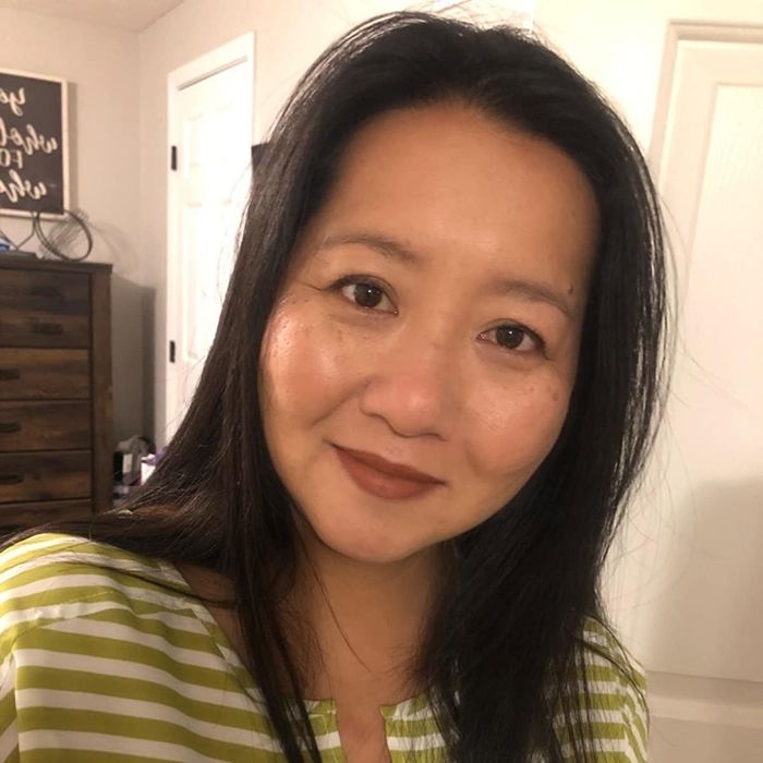 A reviewer flaunting a rich dark brown shade of the lipstick