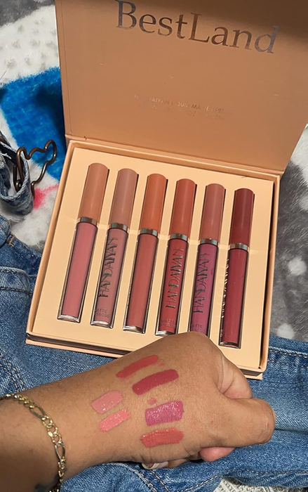 A reviewer showcasing the lipstick set with swatches on her hand.