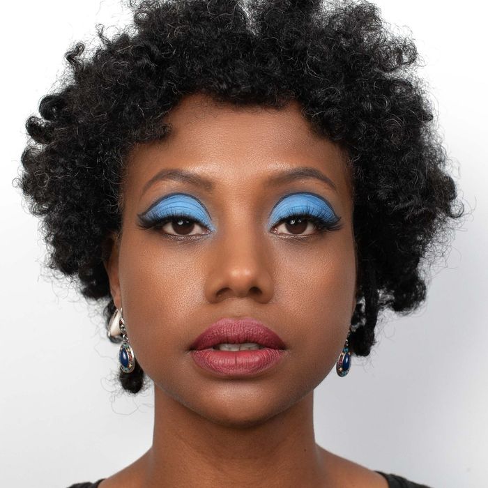 a model showcasing a vibrant blue eyeshadow look created using the matriarch palette