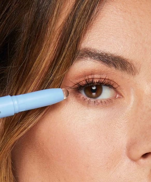 Close-up shot of a person using the makeup touchup pen to fix a small makeup mistake near their eye