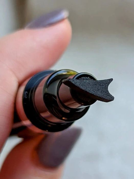 The reviewer’s eyeliner pen with a wing-shaped stamp on the end