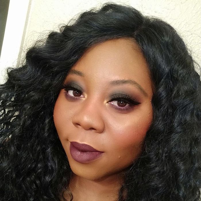 A reviewer rocking a deep purple shade of the lipstick