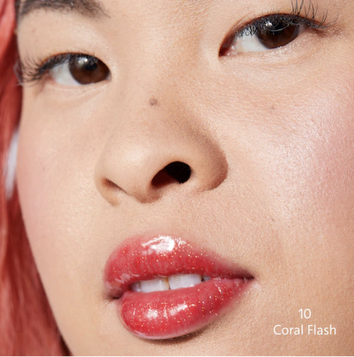 A model wearing coral lip gloss.