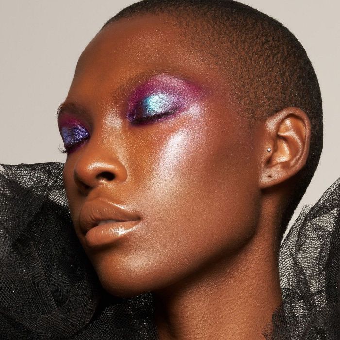 a model showcasing vibrant blue, pink, and purple pigment on their eyelids