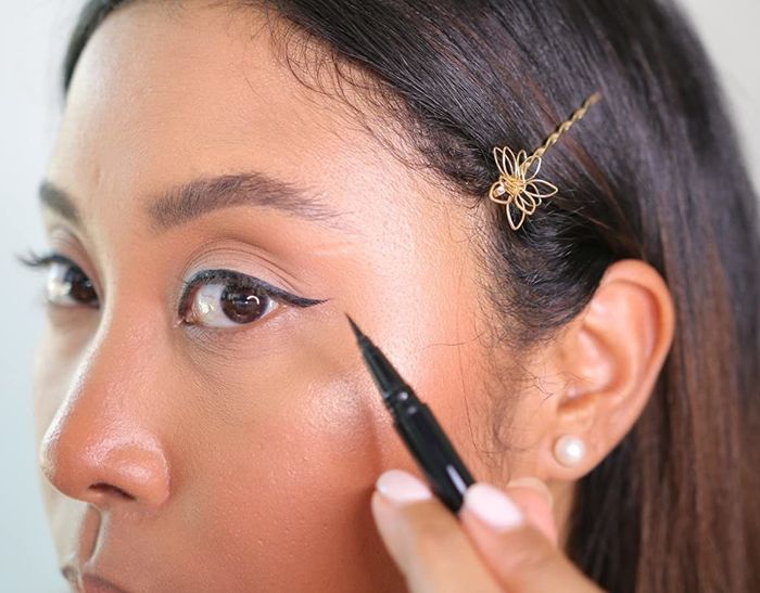 a reviewer applying the eyeliner with precision