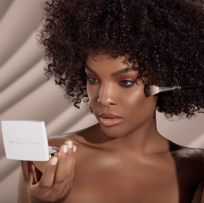 a model applying the iced out highlighter to their cheekbones