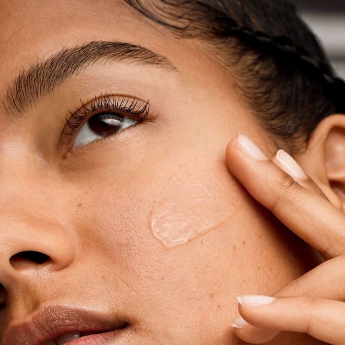 a model applying the primer to their face for a smooth base