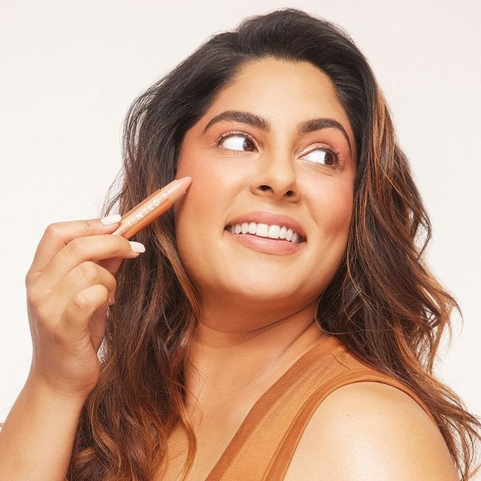 a model applying the Huestick to their face
