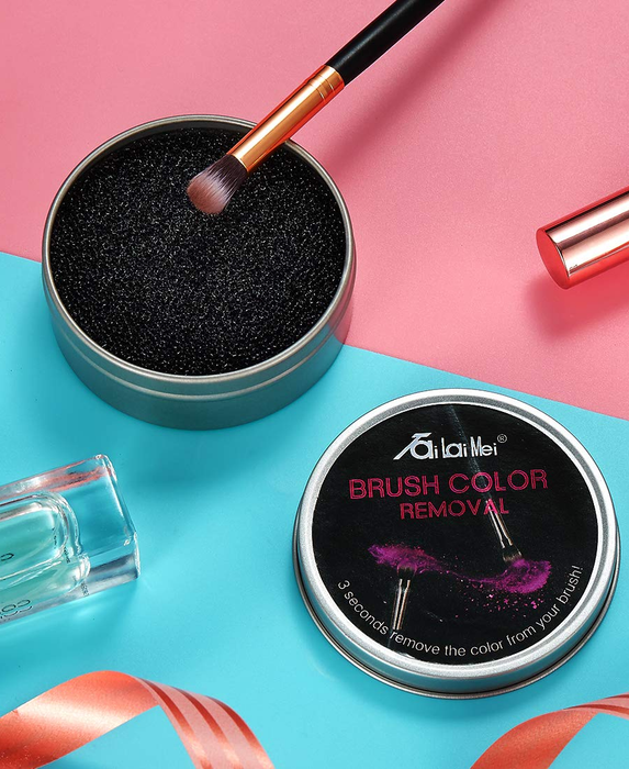 A product photo of an eyeshadow brush being dipped into the container.