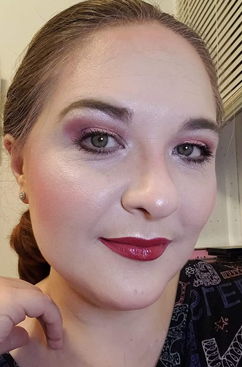 A reviewer showcasing blush and highlighter applied to their cheeks