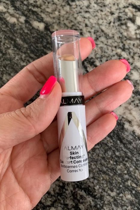 A reviewer holding the concealer for demonstration
