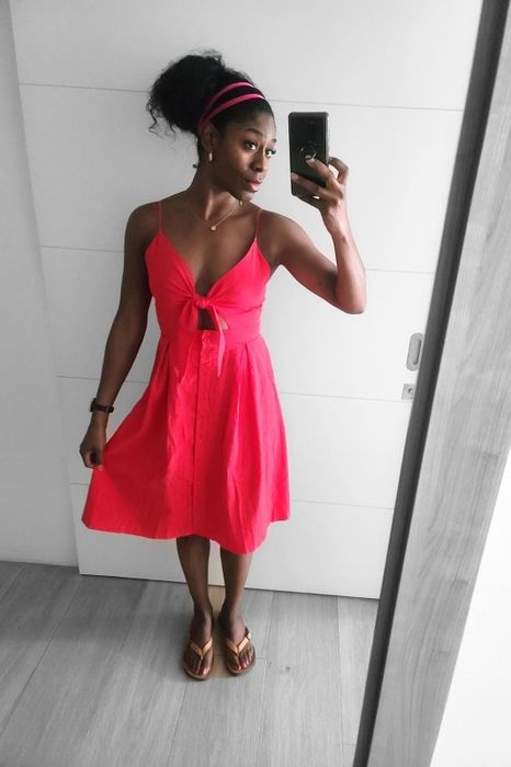 reviewer in a sleeveless knee-length dress taking a mirror selfie