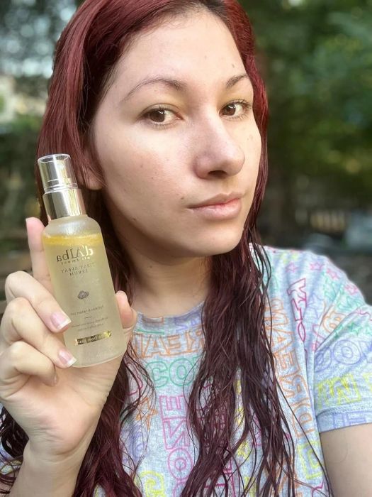The reviewer holding the serum bottle after application.