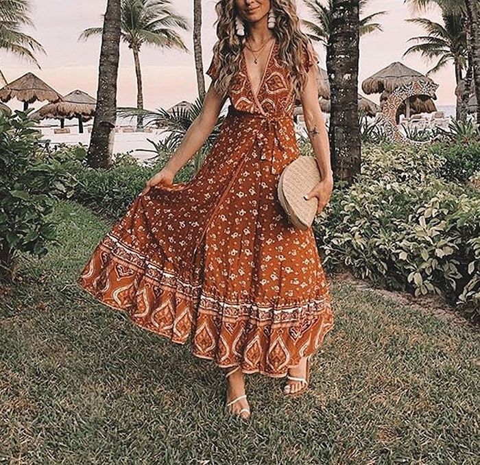 A model showcases the ruffled sleeve maxi dress in a vibrant tangerine hue.