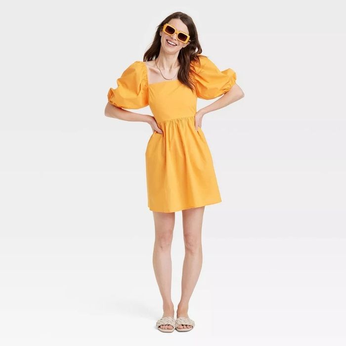 A model showcasing the yellow puff sleeve dress
