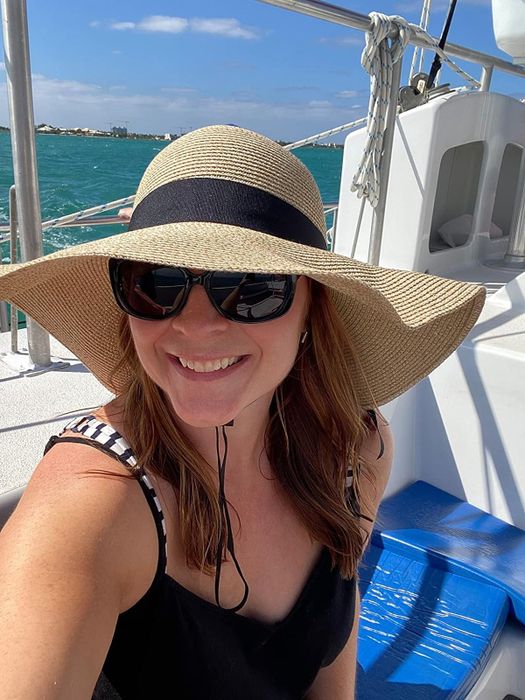 A reviewer wearing a wide-brimmed sunhat and sunglasses