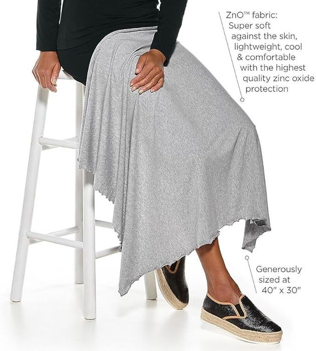A model holding a gray blanket made of ZnO fabric across their lap