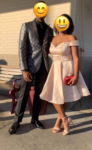 reviewer wearing a light pink dress posing with her date