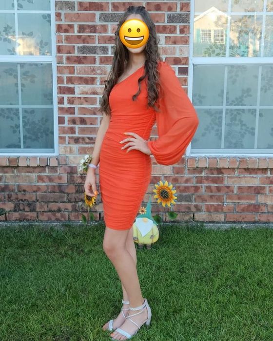 reviewer modeling an orange dress