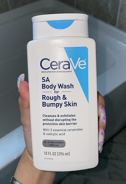 Reviewer holding up a bottle of body wash