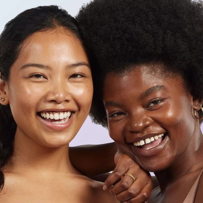 Two models smiling at the camera, their skin glowing with health