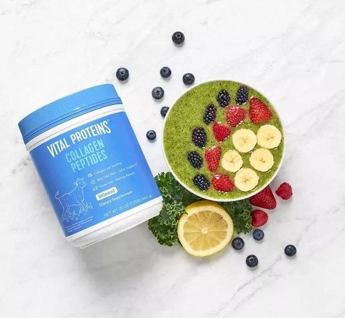 Vital Proteins Collagen Peptides container placed next to a smoothie bowl topped with banana slices, berries, and a lemon slice