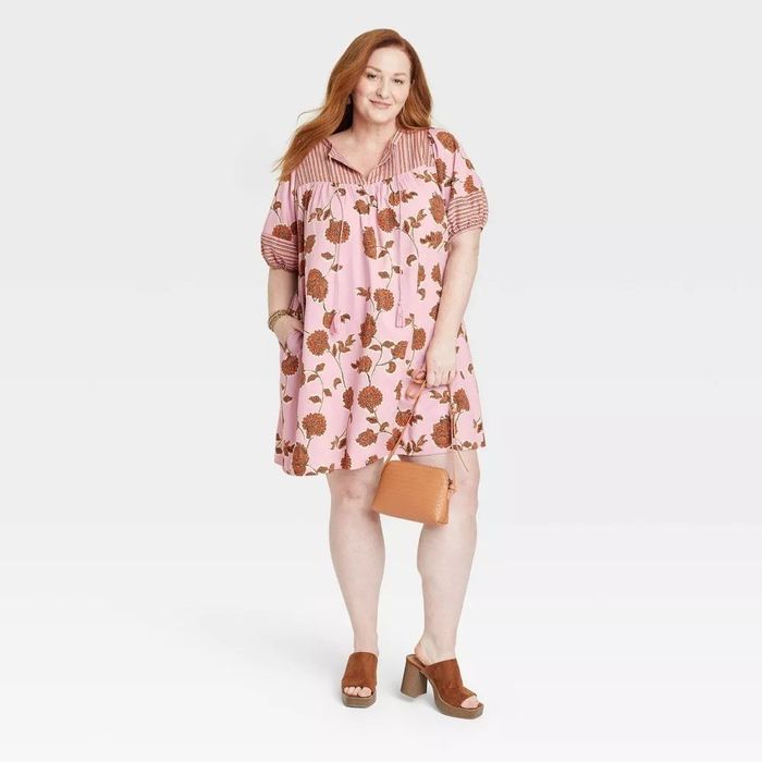 A model showcasing the pink and ochre floral dress