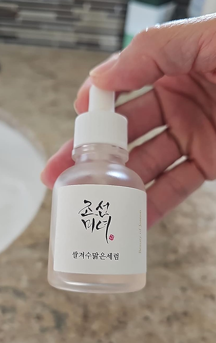 A reviewer holding the glow serum