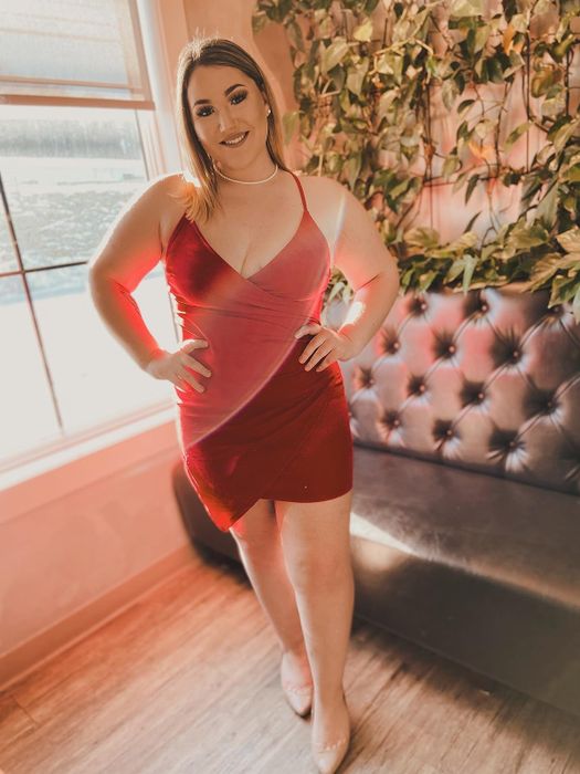 reviewer showcasing a red dress