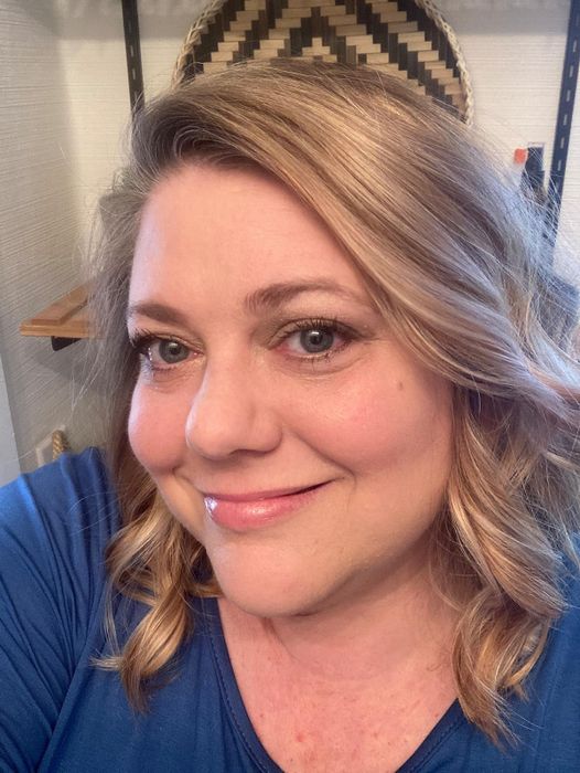 A reviewer smiling, showcasing smooth skin with foundation applied