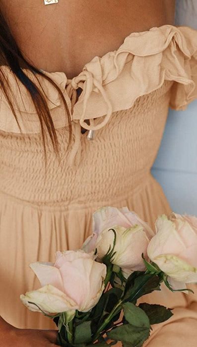 A detailed close-up of the ruffled and smocked bodice of the dress.