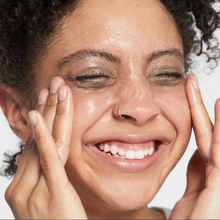 Model applying the balm to their face