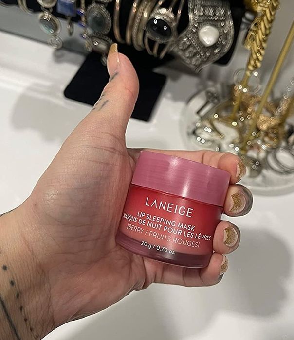 A reviewer showing off the pink container of Laneige lip mask, ready for overnight hydration.