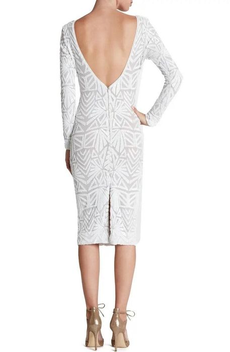 Model wearing a white sequin dress, showcasing the low-cut back
