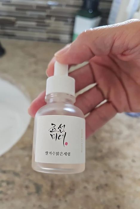 A reviewer proudly holding the serum bottle