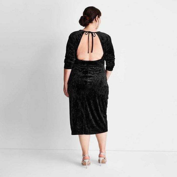 Back view of the same dress on the same model, highlighting the open design
